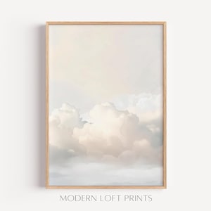 Könnte beinhalten: Ein gerahmter Kunstdruck mit einem Aquarellgemälde eines bewölkten Himmels in sanften Pastellfarben. Das Kunstwerk hat einen hellen Holzrahmen und der Text "MODERN LOFT PRINTS" befindet sich unten.
