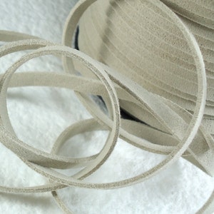 May include: A close-up of a spool of beige leather cord. The cord is soft and supple, and it is perfect for crafting projects.