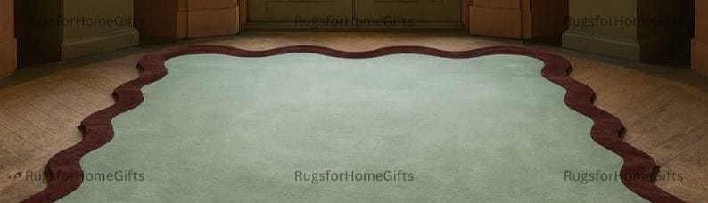 May include: A large, pale green rug with a dark red, wavy border. The rug is placed on a wooden floor, with a doorway in the background. The rug's distinctive shape and colour scheme create a striking visual contrast.
