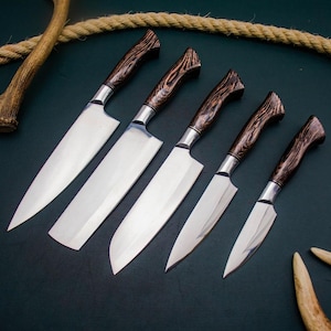 May include: A set of five stainless steel kitchen knives with dark brown wooden handles. The blades are polished and reflect light. The handles have a unique wood grain pattern. Knives are arranged diagonally on a dark surface.