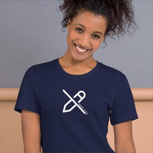 Puede incluir: Camiseta azul marino con un gráfico blanco de un lápiz cruzado con la letra "A" y las palabras "read only". La camiseta está hecha de un material suave.