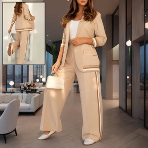 Puede incluir: Un traje pantal&oacute;n beige con una blazer a juego. La blazer tiene solapas con muescas, mangas tres cuartos y un bolsillo. El pantal&oacute;n es de pernera ancha con una raya vertical. El conjunto se complementa con un bolso blanco y zapatos blancos. El traje tiene rayas marrones y blancas.