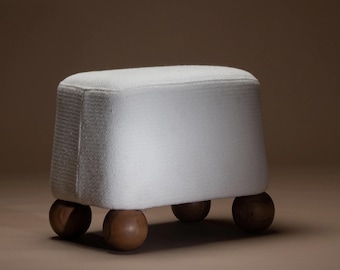 Puf otomano tapizado en color crema – Patas esféricas de madera maciza, asiento reposapiés minimalista