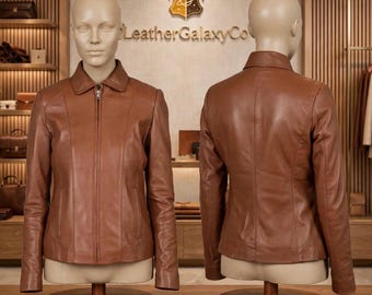 May include: A tan leather jacket displayed on two mannequins showing the front and back views. The jacket features a classic collar, a full-length center zipper, long sleeves, and vertical seam detailing. The brand name LeatherGalaxyCo is visible.