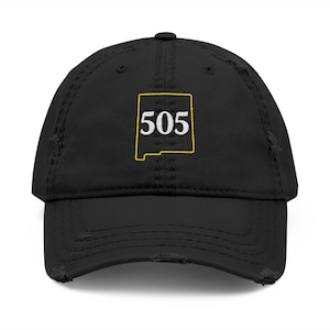 May include: Black distressed baseball cap featuring the number "505" inside a yellow outline of the state of New Mexico. The cap has a curved brim and a distressed, worn look.