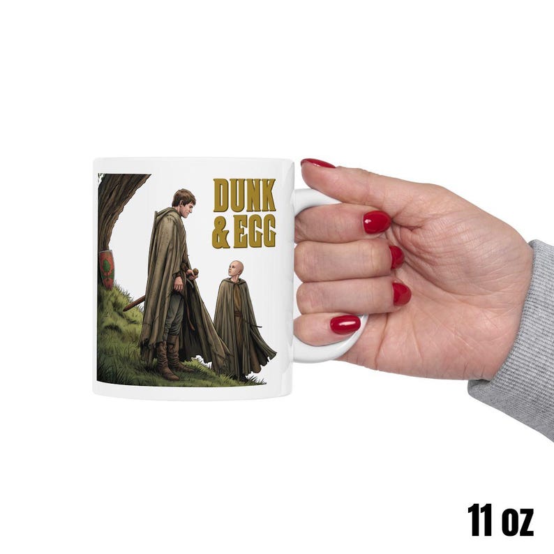 Może przedstawiać: Biały ceramiczny kubek z czarnym uchwytem i napisem "But First, Coffee" w stylu odręcznym. Kubek stoi na białej powierzchni. Kubek ma około 10 cm wysokości.