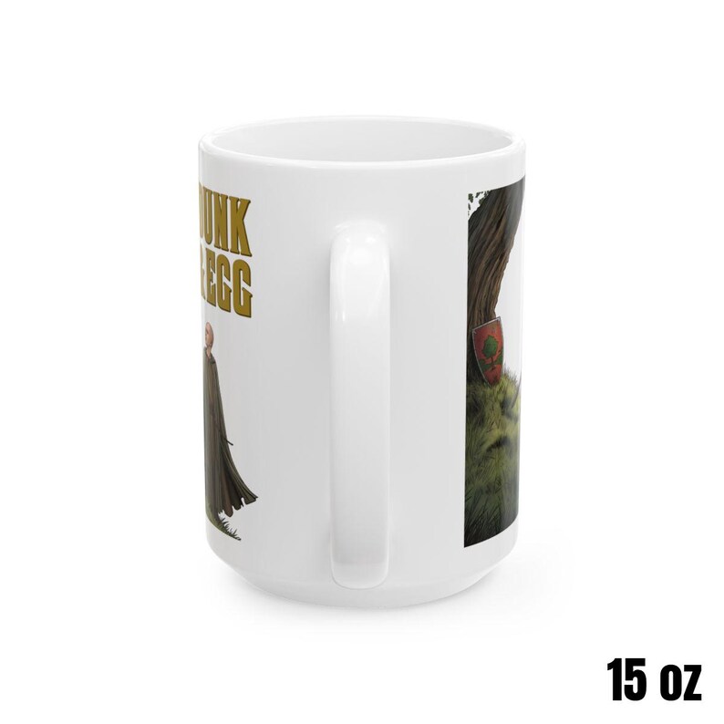 Może przedstawiać: Biały ceramiczny kubek z owiniętym wzorem przedstawiającym postać z historii fantasy. Kubek ma napis "Junk Egg" złotymi literami. Kubek ma 444 ml.