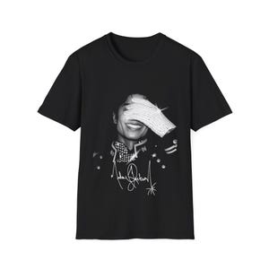 May include: Black t-shirt with a black and white image of a smiling person wearing a jeweled glove, covering their eyes. The image includes a signature at the bottom. The t-shirt has a classic crew neck.