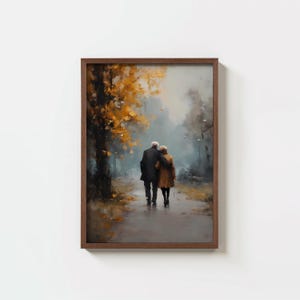 May include: A framed art print depicting an elderly couple strolling through a park. The painting features a muted color palette with a focus on the couple's figures and the autumn foliage. The frame is a dark brown color.