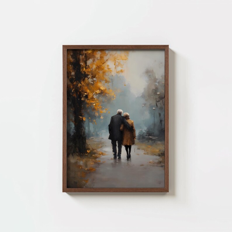 May include: A framed art print depicting an elderly couple strolling through a park. The painting features a muted color palette with a focus on the couple's figures and the autumn foliage. The frame is a dark brown color.