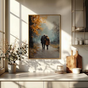 May include: A framed art print depicts an elderly couple walking on a path in a park. The artwork features a muted color palette with shades of brown, gold, and gray. The couple is seen from behind, with the man in a dark coat and the woman in a tan coat.