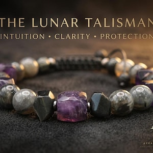 Può includere: Un braccialetto di perline con cubi di ametista viola sfaccettati, sfere di labradorite grigia liscia e perline geometriche metalliche scure. Il testo THE LUNAR TALISMAN INTUITION CLARITY PROTECTION e il logo AZR sono visibili nell'immagine.