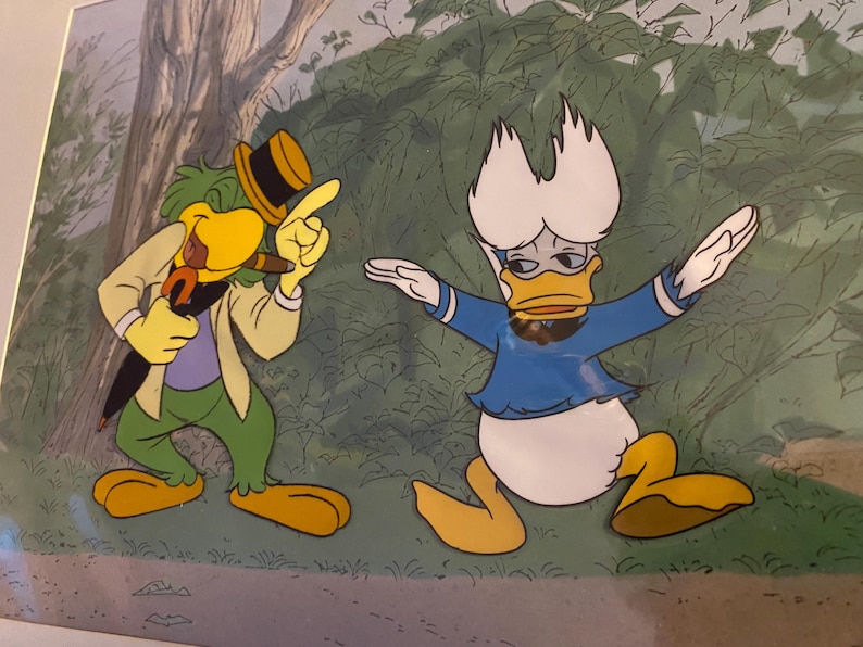 K&ouml;nnte beinhalten: Eine Cartoon-Illustration eines gr&uuml;nen und gelben Vogels mit Hut und einer blauen Ente mit blauem Hemd. Der Vogel h&auml;lt einen braunen Stock im Schnabel und die Ente h&auml;lt ihre Fl&uuml;gel ausgestreckt.