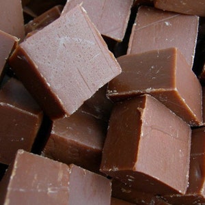 May include: A close-up of a pile of brown chocolate fudge squares.