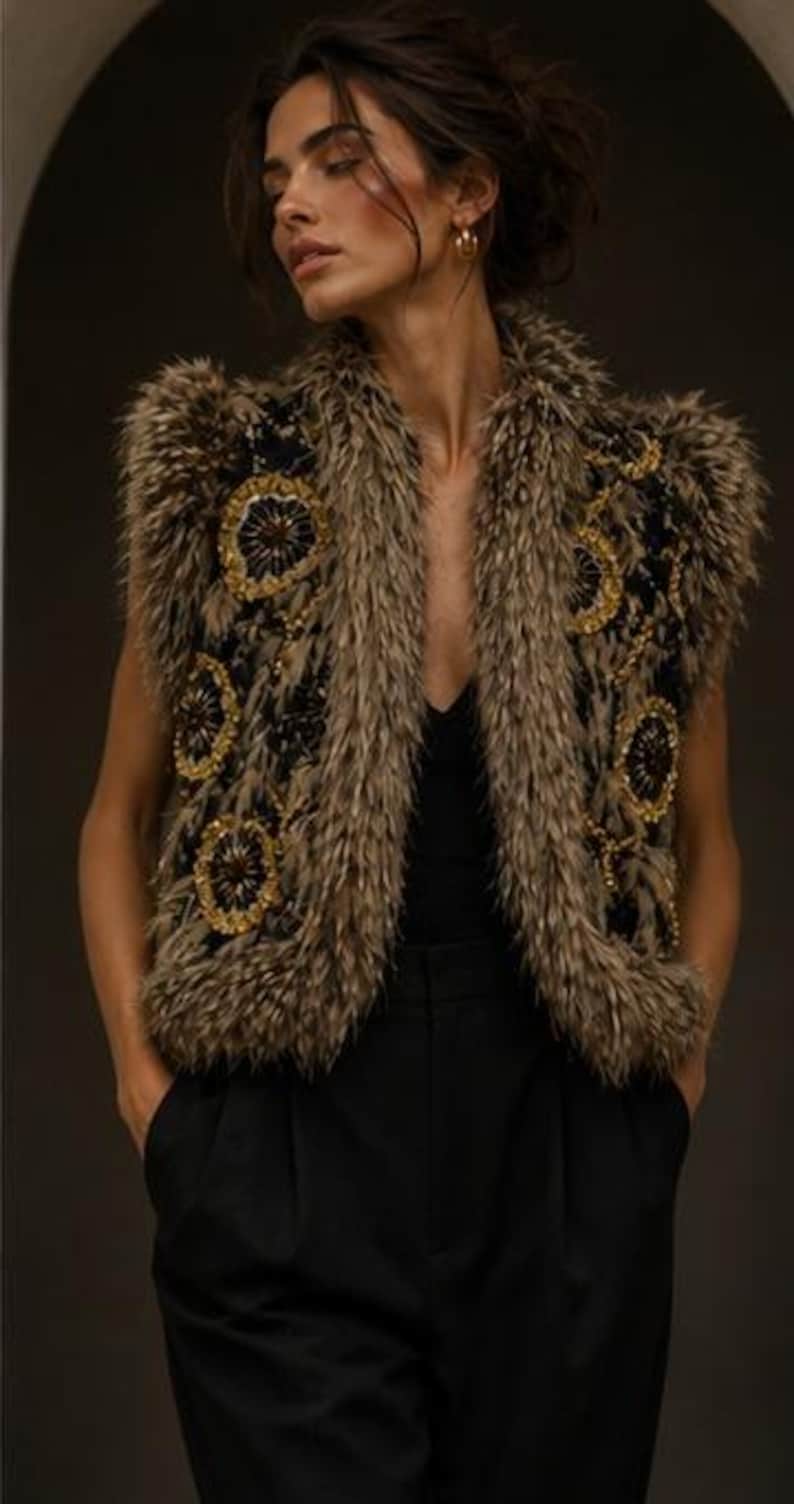 May include: A sleeveless vest featuring a black base with textured brown faux fur trim along the edges and shoulders. The garment is adorned with circular gold and black beaded floral embroidery patterns throughout the front panels.