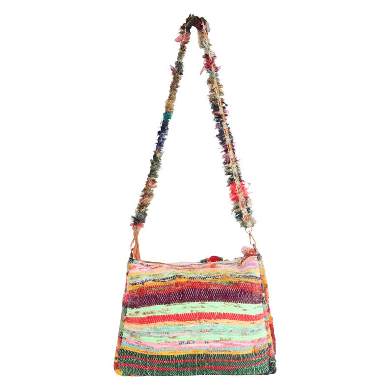 May include: A colorful shoulder bag with a striped pattern in shades of red, green, yellow, and purple. The bag has a long strap made of knotted fabric and a metal clasp.