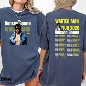 Könnte beinhalten: Ein denimblaues T-Shirt mit dem Text "Benson Boone" und "WANTED MAN TOUR 2026" und einem Foto eines Mannes. Auf der Rückseite des Shirts sind Tourdaten aufgeführt. Das Wort "DENIM" ist unten aufgedruckt.