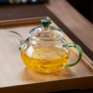 Puede incluir: Un letrero de madera hecho a mano con la palabra "Bienvenido" en una fuente juguetona. El letrero está pintado de blanco con un acabado envejecido y presenta un diseño floral en tonos rosas y verdes. Mide aproximadamente 30 cm de ancho.