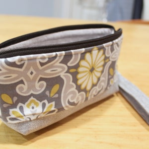 Cartera tipo sobre con cremallera y estampado botánico, color gris y amarillo, con estampado bohemio
