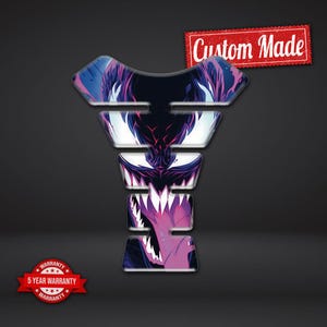 May include: A custom-made motorcycle tank protector with a graphic design featuring a monster face with sharp teeth in shades of purple, white, and blue. The text "Custom Made" is in a red banner.