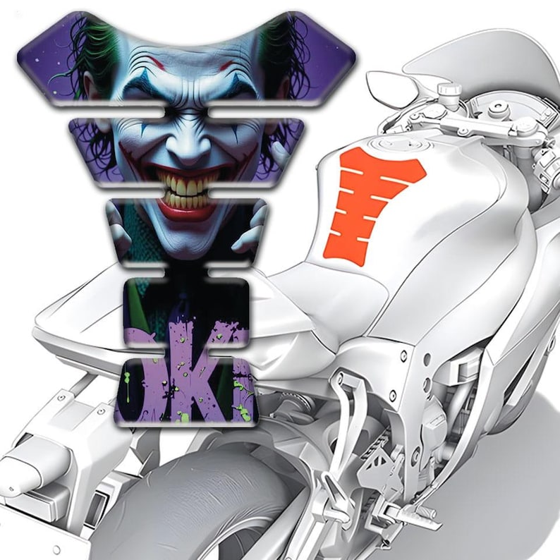 May include: A motorcycle with a custom tank protector featuring a detailed image of the Joker's face. The protector is multi-layered and includes the word "JOKE" in a graffiti style. An orange tank pad is also visible.