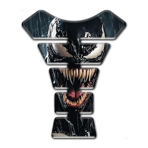 Peut inclure: Un protecteur de réservoir de moto avec un graphisme du personnage Venom. Le design est principalement noir et blanc, représentant le visage du personnage avec des dents pointues et une longue langue.