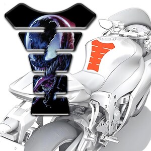 May include: A white motorcycle with a black, blue, and red graphic of a monster on the gas tank. An orange tank protector is also visible. The motorcycle has a sleek, modern design.