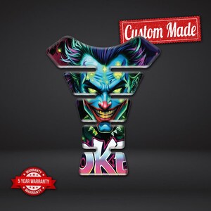 May include: A custom-made motorcycle tank protector featuring a colorful illustration of a character with green hair, blue skin, and a wide grin. The design includes the word "OK" in a graffiti style. A red banner reads "Custom Made".