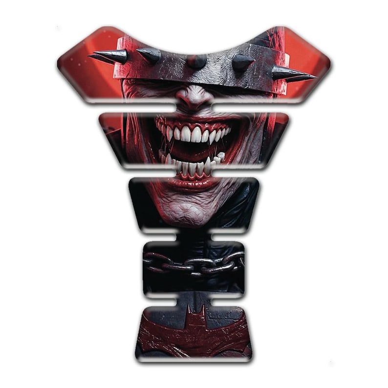 May include: A motorcycle tank protector featuring a menacing, detailed illustration of a character with a spiked headpiece and a wide, sinister grin. The design incorporates a Batman symbol at the bottom, with a red and black color scheme.