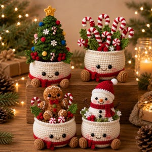 May include: Four crocheted festive containers featuring smiling faces, red scarves, and brown feet. One holds a green Christmas tree with ornaments, one holds candy canes and holly, one holds a gingerbread person, and one holds a snowman.