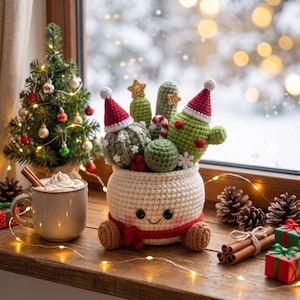 May include: A crocheted white pot with a smiling face and red scarf, filled with various green crocheted cacti. The cacti are decorated with small red and white Santa hats, gold stars, a candy cane, and white snowflakes. Red berries sit at the base.