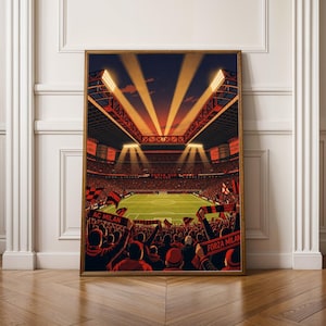 May include: A vertical poster depicting a soccer stadium at night with bright floodlights illuminating the green pitch. The stands are filled with a crowd holding red and black scarves with the text AC MILAN and FORZA MILAN visible.