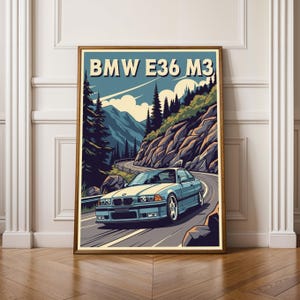 May include: A framed art print depicting a light blue BMW E36 M3 car on a mountain road. The artwork has a retro style with a blue sky, mountains, and trees. The text "BMW E36 M3" is displayed at the top of the print.