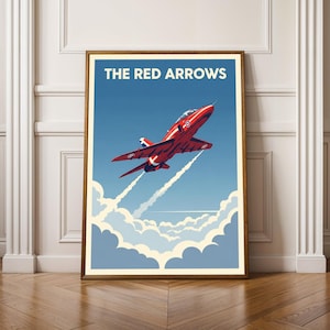 May include: A framed poster featuring a red jet plane soaring through a blue sky with white clouds. The text "THE RED ARROWS" is displayed at the top. The artwork is in a vintage style, with a wooden frame.