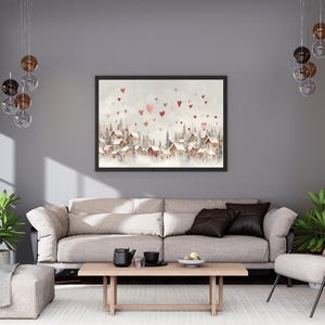 May include: A framed watercolor painting depicts a snow-covered village with red-roofed houses and heart-shaped accents. The artwork is set against a soft, neutral background, creating a cozy, romantic atmosphere. The painting is displayed above a beige sofa.