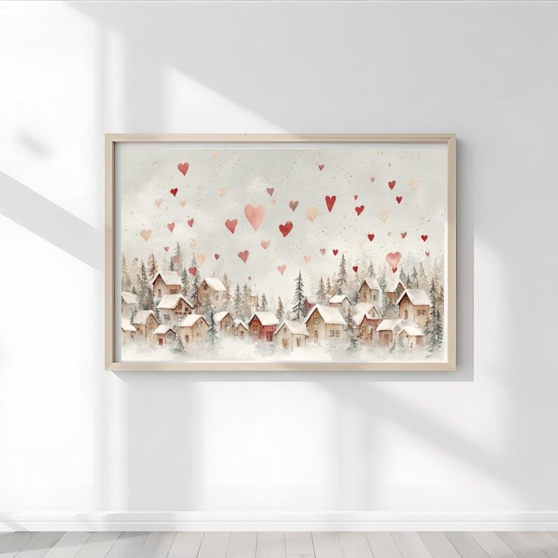 May include: Watercolor painting of a village nestled among evergreen trees, with red heart shapes floating in the sky. The artwork is framed in a light wood frame, creating a cozy and romantic scene.