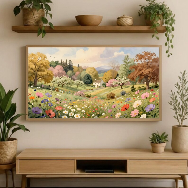 May include: A rectangular landscape painting featuring a rolling meadow filled with colorful wildflowers in shades of pink, red, orange, and purple. A small white house sits in the distance among lush green trees and autumn-toned foliage.
