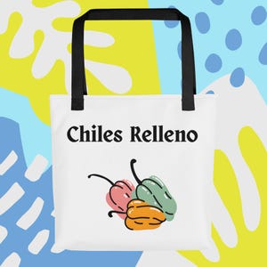 Peut inclure: Sac fourre-tout blanc avec des poignées noires. Il affiche le texte "Chiles Relleno" et une illustration colorée de trois piments. Les piments sont roses, verts et oranges avec des tiges noires.