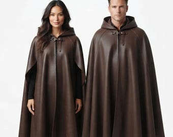 May include: Two dark brown hooded capes made of a smooth, leather-like material. Each cape features a structured hood, a flared silhouette, and a metallic toggle clasp closure at the neck. The garments are worn over dark clothing, showing a clean design.