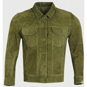 May include: Olive green suede jacket with a collared neckline, two chest pockets, and button closures. The jacket has long sleeves and a classic, tailored fit. The suede material gives it a soft, textured appearance.