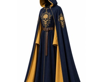 May include: A floor-length navy blue hooded cloak featuring a mustard yellow lining and trim. The garment displays gold-coloured skull graphics within ornate filigree frames on the chest and shoulders, secured at the waist with a brown leather belt.