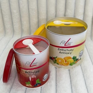 Könnte beinhalten: Zwei zylindrische FitLine-Nahrungsergänzungsmittelbehälter. Einer ist rot und weiß mit dem Text "Activize Oxyplus", der andere ist gelb und weiß mit dem Text "Zellschutz Antioxy". Jeder hat einen weißen Löffel und einen Deckel.