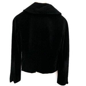 May include: A black velvet blazer with a wide collar and long sleeves.