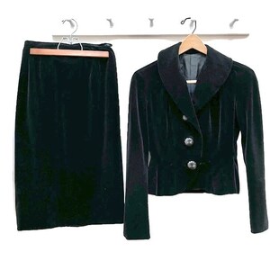 May include: A black velvet skirt and jacket set. The jacket has a wide collar and button closure.