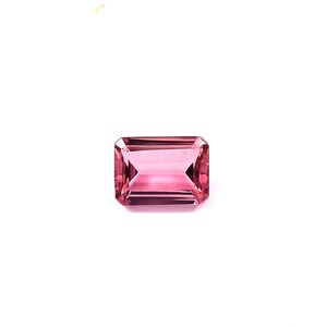May include: A rectangular-cut, pink gemstone with a faceted surface. The gem has a vibrant, rosy hue and is set against a white background. The gemstone's facets reflect light, creating a sparkling effect. This gemstone is suitable for jewelry making.