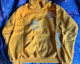 Sudadera amarilla grande con capucha de Keith Haring. Gráficos de doble cara. 50% algodón, 50% poliéster. Usada en excelente estado.