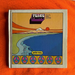 May include: A vintage book cover with the word "PEACE" in a 3D purple font. The cover features a colorful illustration of a mountain range, a body of water, and a setting sun. The bottom of the cover has peace symbols.