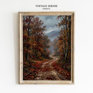 Könnte beinhalten: Ein gerahmter Kunstdruck mit dem Titel VINTAGE SERENE PRINTS zeigt einen gewundenen Feldweg durch einen dichten Wald im Herbst. Die Bäume zeigen leuchtend orangefarbenes, rotes und braunes Laub, während abgefallene Blätter unter einem bewölkten Himmel den Boden bedecken.