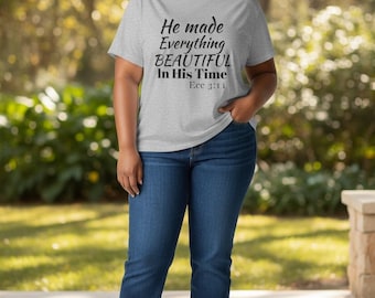 May include: A light grey short-sleeved t-shirt featuring the black printed text "He made Everything BEAUTIFUL In His Time Ecc 3:11" paired with dark blue denim jeans and white trainers. The shirt has a crew neckline and a standard fit.