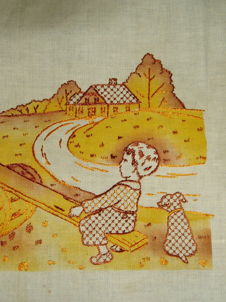 May include: A beige fabric panel featuring an embroidered scene in shades of yellow and brown. The design depicts a child sitting on a seesaw with a small dog nearby, set against a landscape with a house, trees, and a winding path.